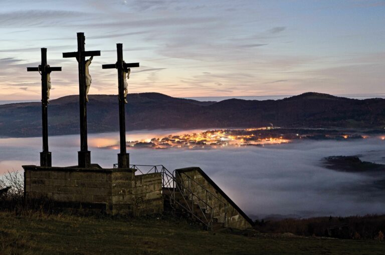 Der Kreuzberg – Blick von den Golgota-Kreuzen auf das abendliche Wildflecken im Nebel.